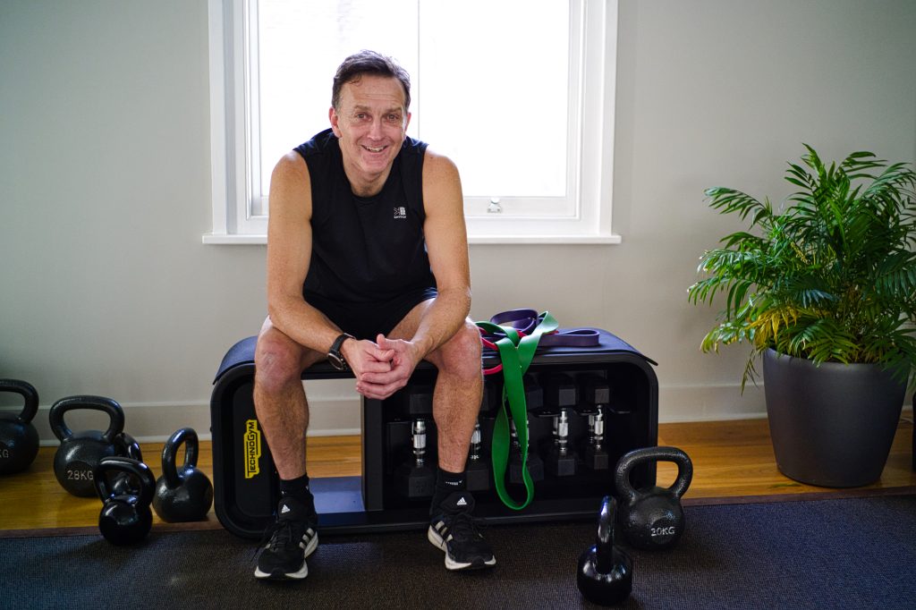sitting on a storage bench with kettlebells around me.