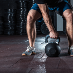 MAN REACHING FOR KETTLEBELL