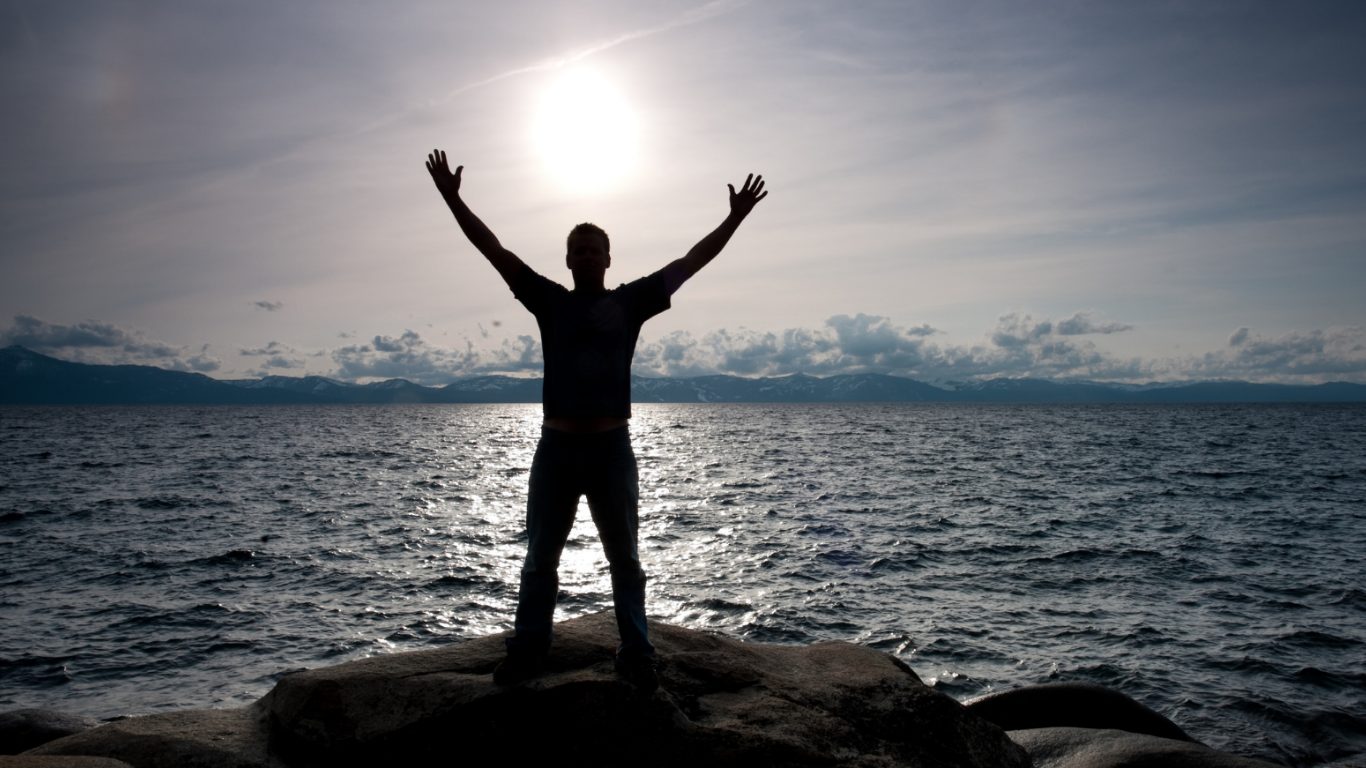 man starring at the sun by the ocean