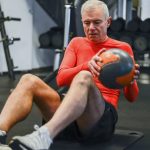 man sitting with a slam ball.