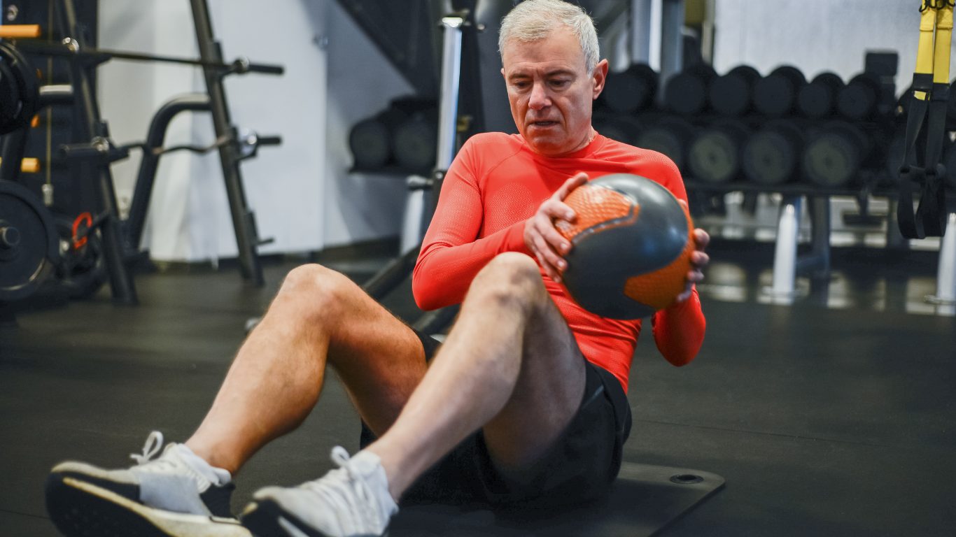 man sitting with a slam ball.