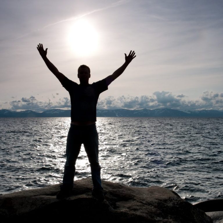 man starring at the sun by the ocean