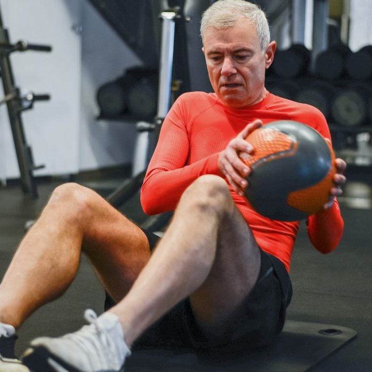 man sitting with a slam ball.
